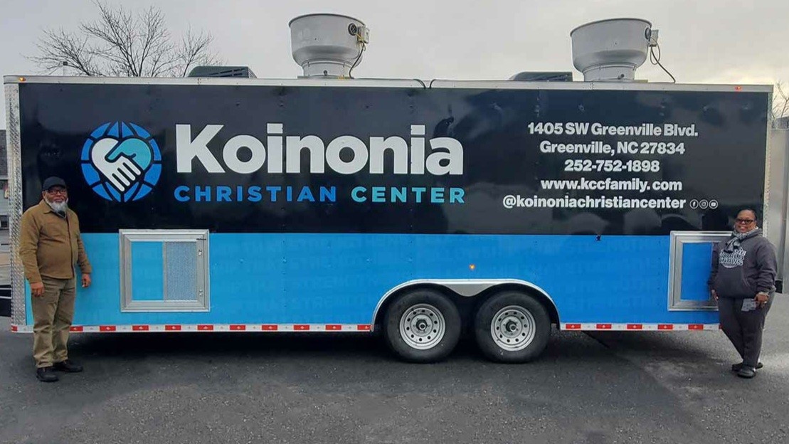 new owners standing next to their new koinonia christan center food trailer